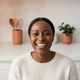Close-up portrait of a smiling woman in her 30s, representing a happy, satisfied customer.